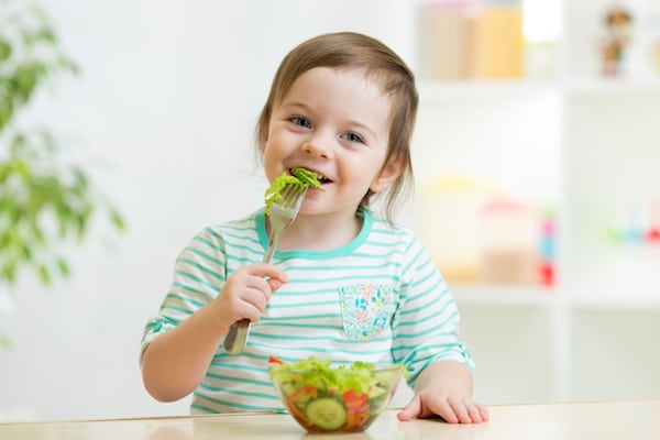 Toddler politely eating with fork